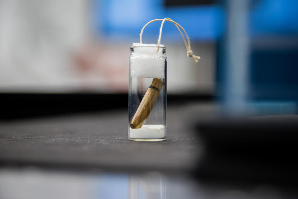 A copper bullet in a glass jar, sealed at the top.