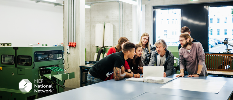 A group of students and their tutor going over their experiment results at an engineering college.