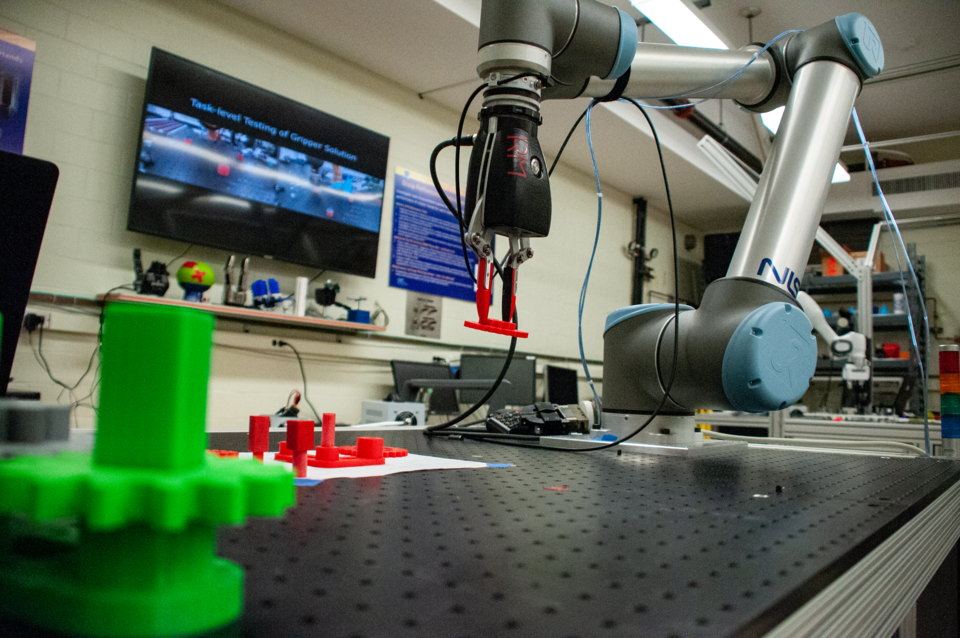 Robot arm picks up a red widget off a table