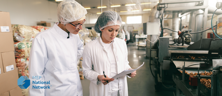 two female factory workers in a food processing plant
