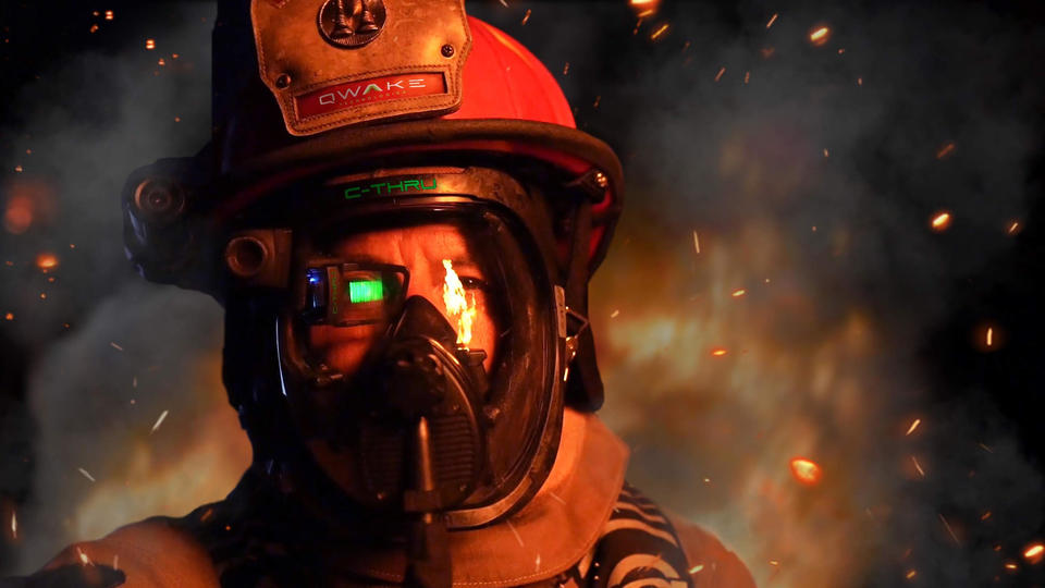 This image shows a firefighter in uniform with a smokey background.