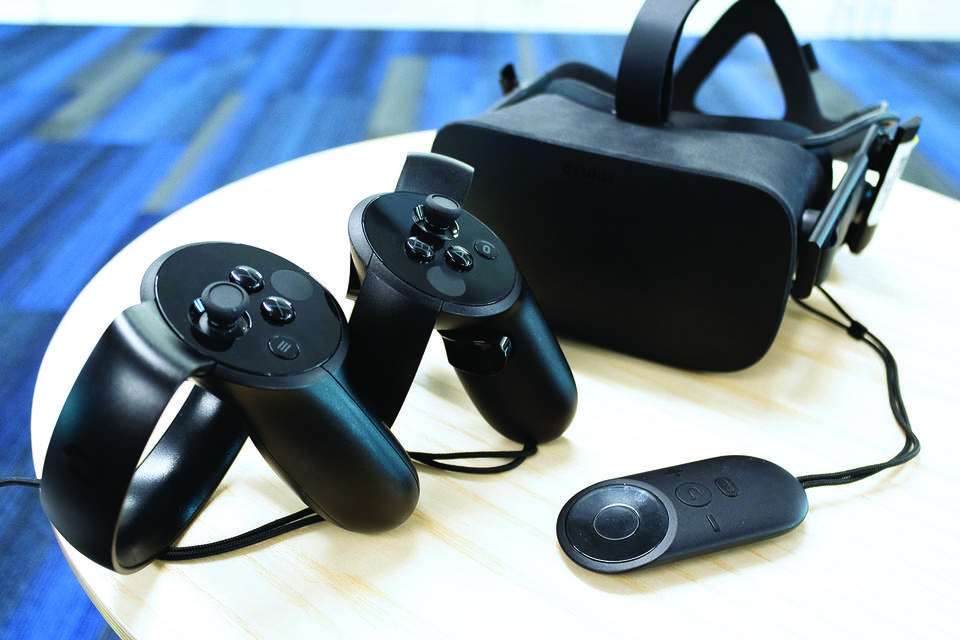 This image shows a virtual reality headset and hand controllers on a white table