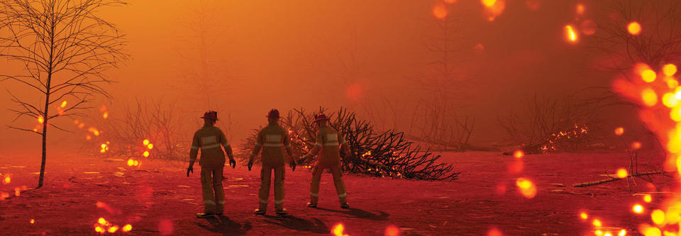 Photo of scorched earth and trees with three firefighters walking away