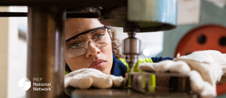 Female apprentice using yoke machine in factory