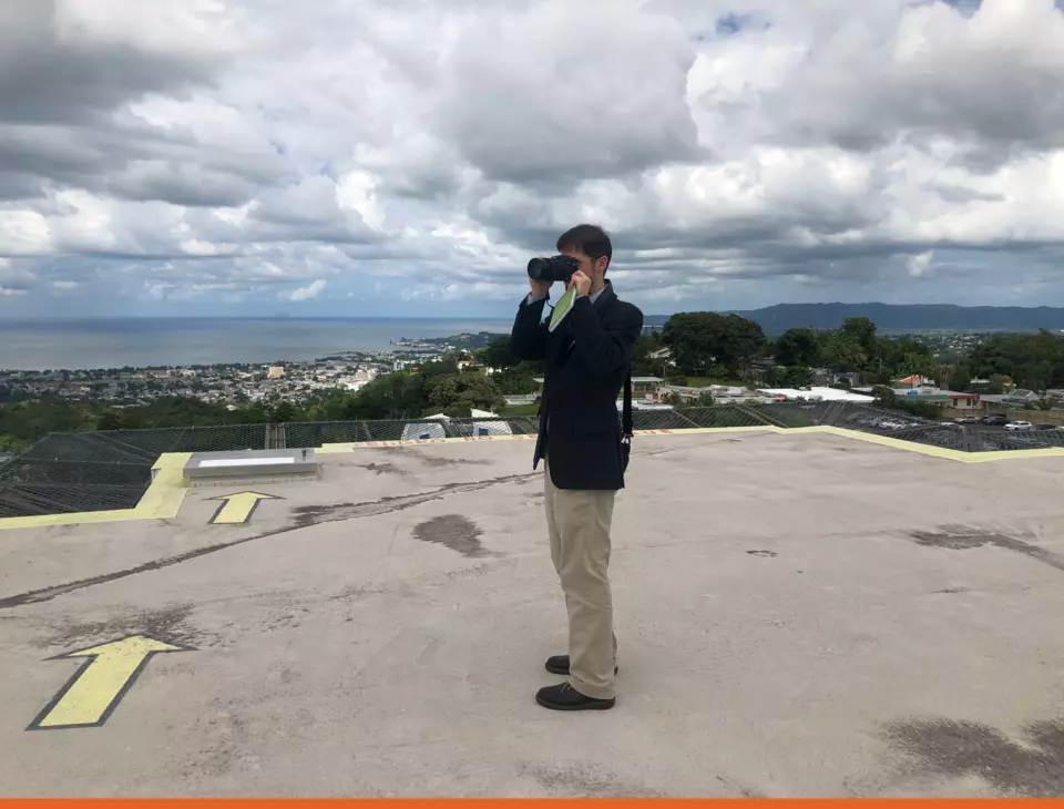 NIST research structural engineer Joe Main on the roof of the Hospital Bella Vista in Mayaguez, Puerto Rico in 2017. Joe is photographing the surrounding terrain to document local topography and surface roughness.