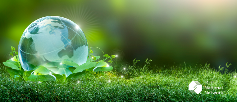 Earth sitting in green leaves on the grass as a renewable energy concept