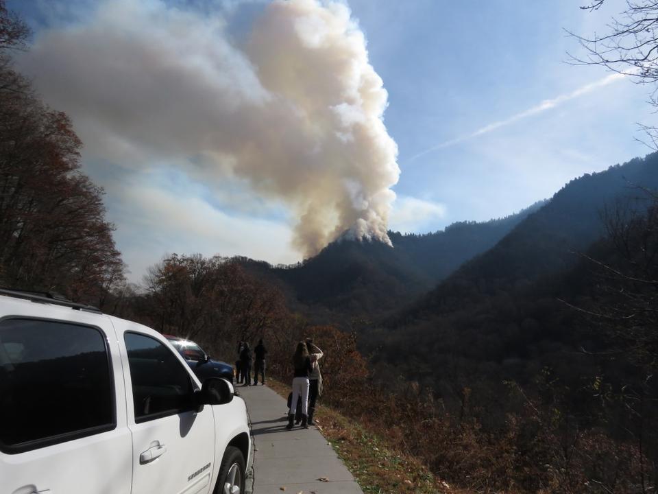 Onlookers view fire burning atop Chimney Tops mountain in Great Smoky Mountain National Park.