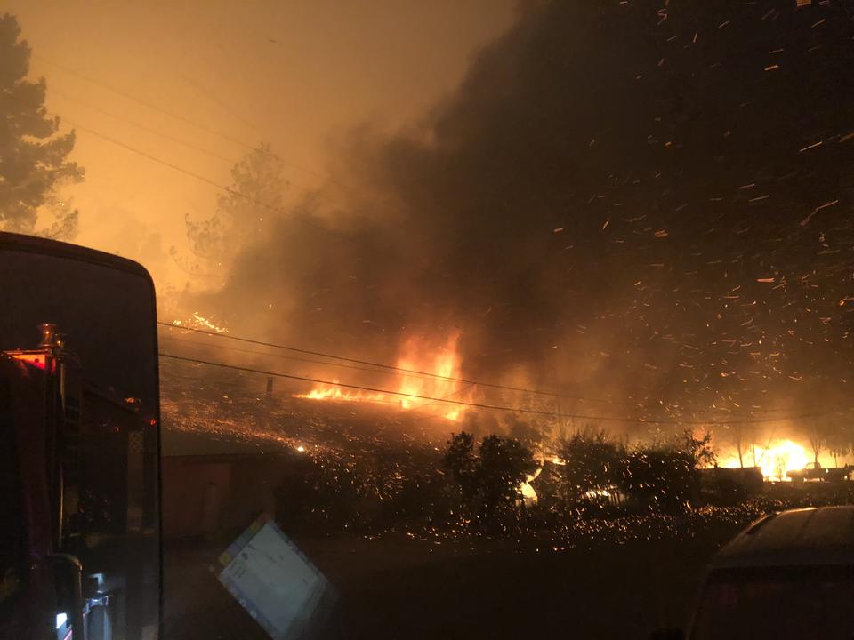 View of flames and glowing embers rising from the ground.