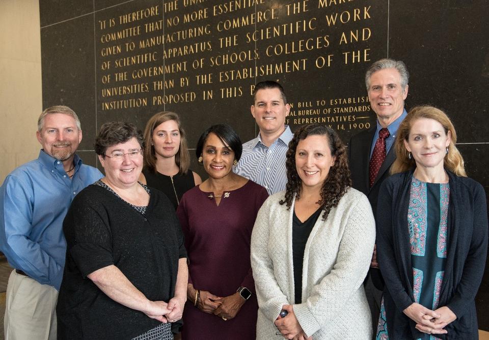 Ellen Garshick and 7 other Baldrige staff members stand as a group.