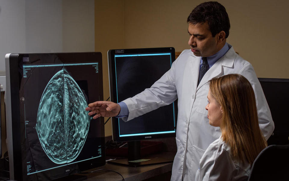 2018 Baldrige Award Recipient Memorial Hospital and Health Care Center photo of a male doctor reviewing x-rays of a female patient.