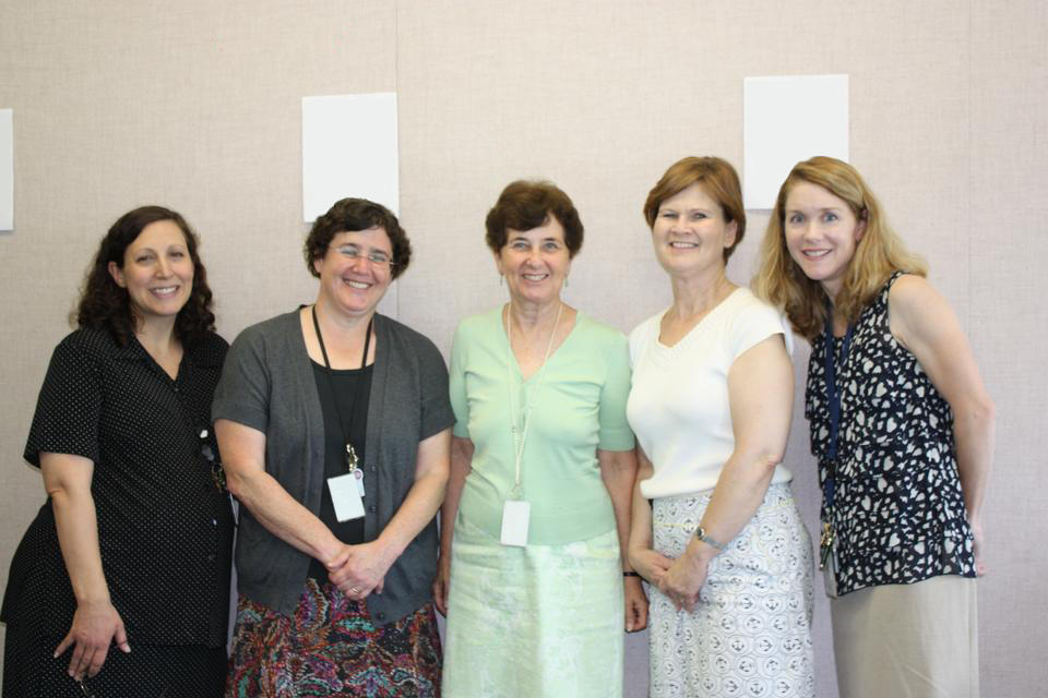 Five women from the Badldrige Publications Management Team stand side by side, smiling