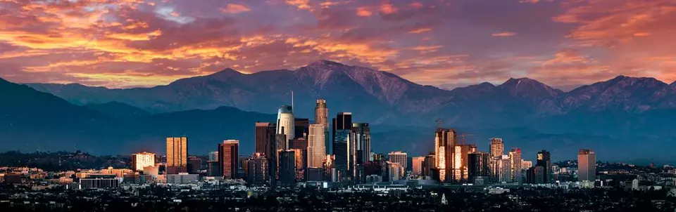 Downtown Los Angeles at sunset, with mountains in the background