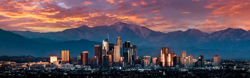 Downtown Los Angeles at sunset, with mountains in the background
