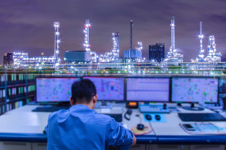 Engineering works with the tablet in the production control room.Control room of a steam Turbine,Generators of Oil refinery industry plant for monitor process, business and industry concept