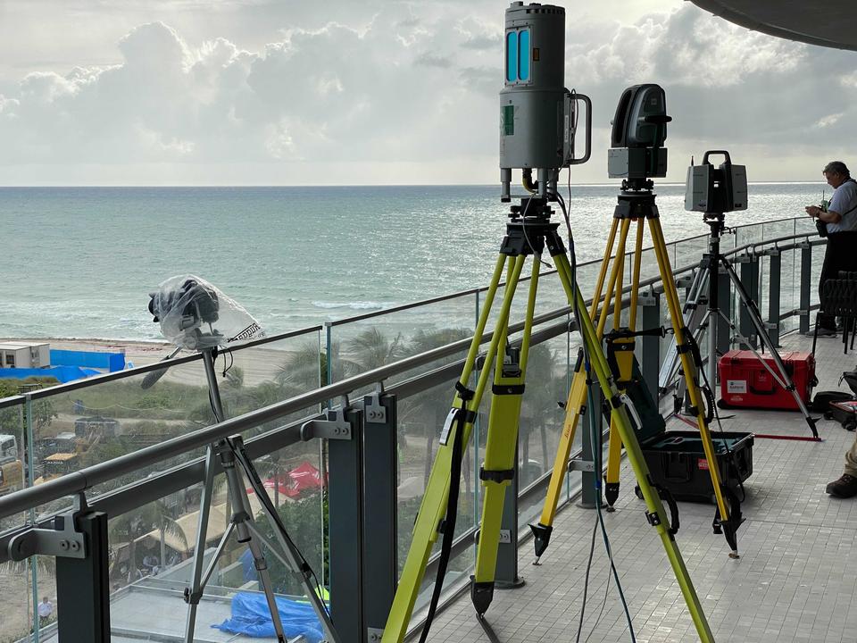 Equipment stands on tripods on a balcony with the beach and sea in the background.