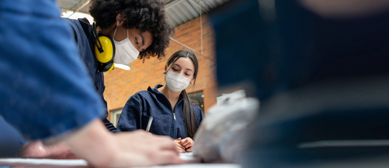 Students in a manufacturing class at school wearing facemasks 