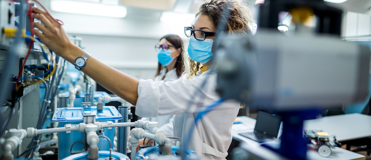 Female engineers with face masks working in laboratory