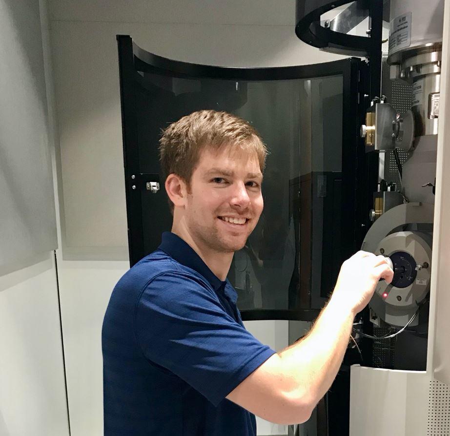 Jake Benzing places a sample in a microscope