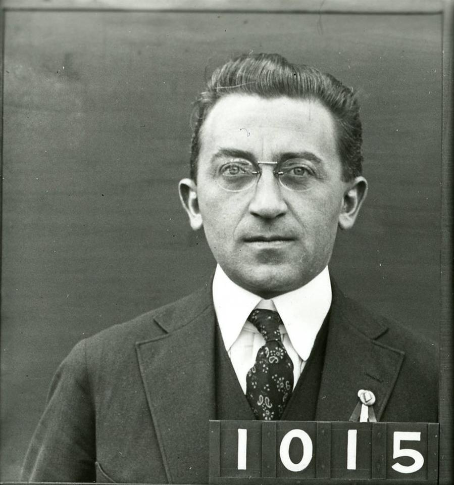black and white headshot of a man in a 3-piece suit and tie. The numbers 1015 are in the lower right corner.