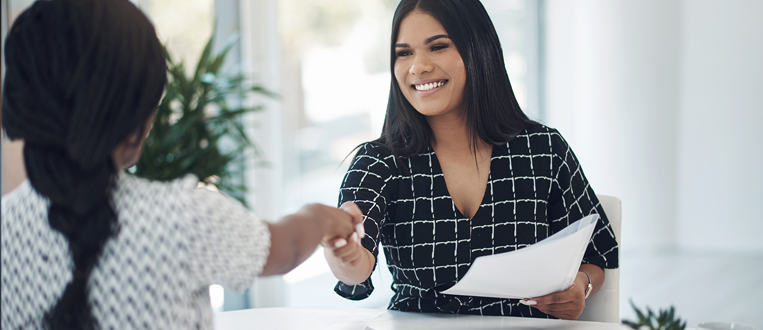 Shot of two young businesswomen shaking hands in a modern office