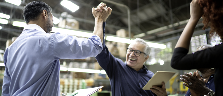 Coworkers celebrating some good news in a factory