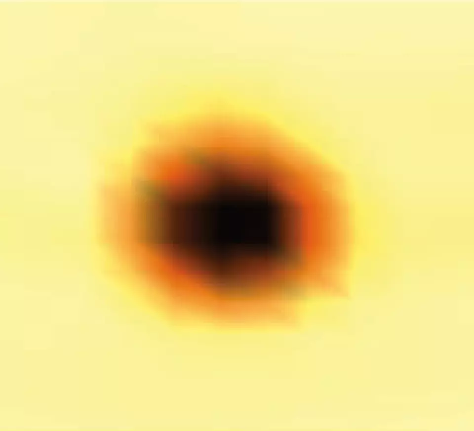 A blurry dark circle lightens at the edges on a yellow background.