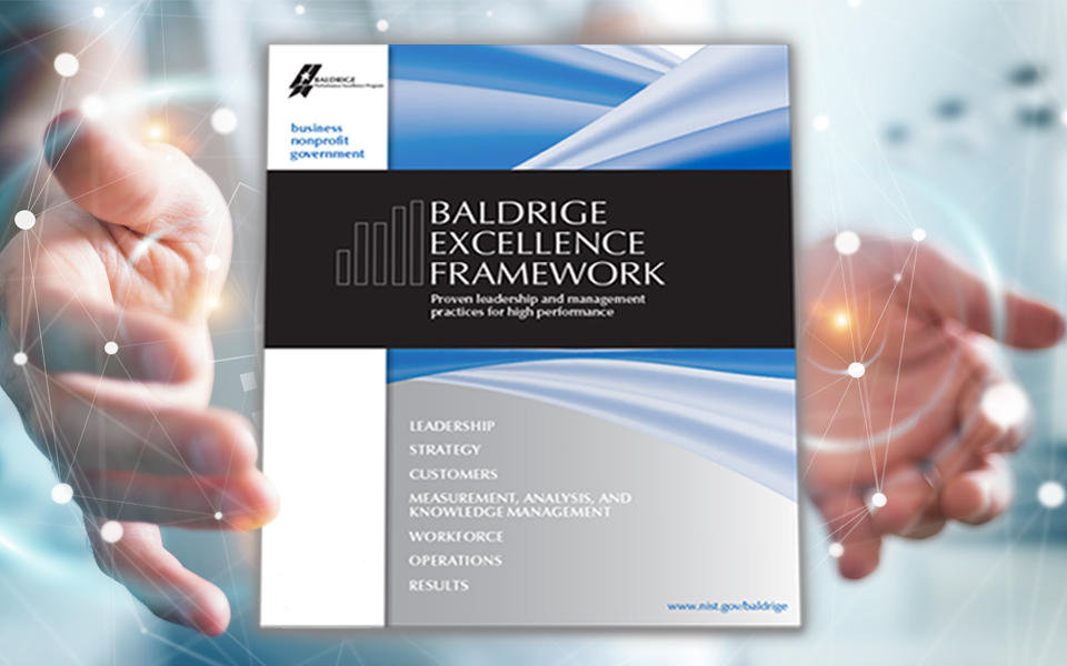 Person wrapping hands around the Baldrige Excellence Framework booklet.