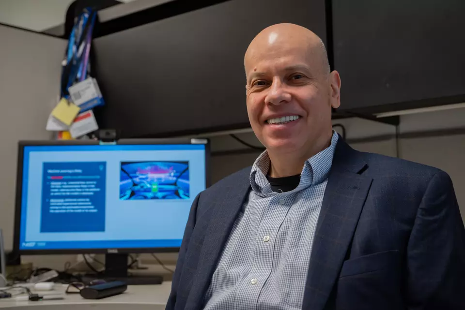 Apostol Vassilev poses for a photo with a computer monitor in the background.