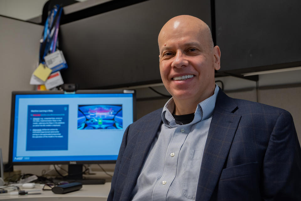 Apostol Vassilev poses for a photo with a computer monitor in the background.