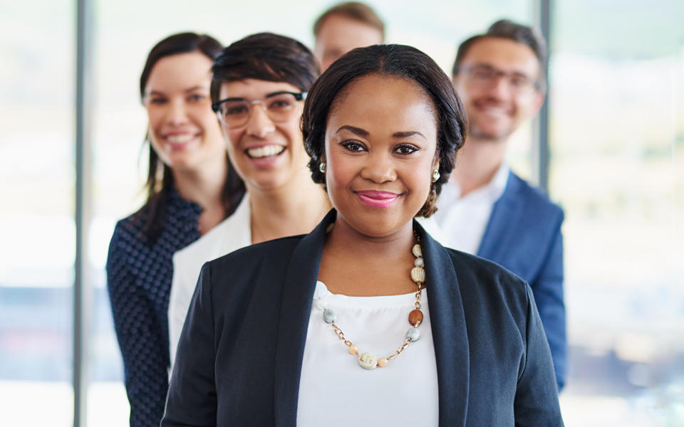 Group of co-workers standing together in conference room. 