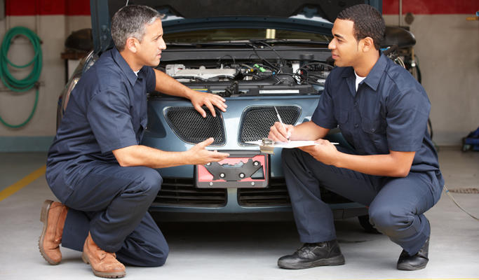 Two mechanics talking about a safe working environment.