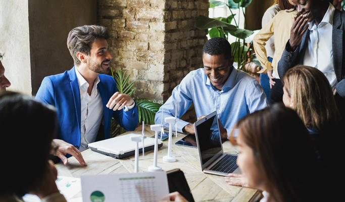 Diverse co-workers meeting about a project at a table.