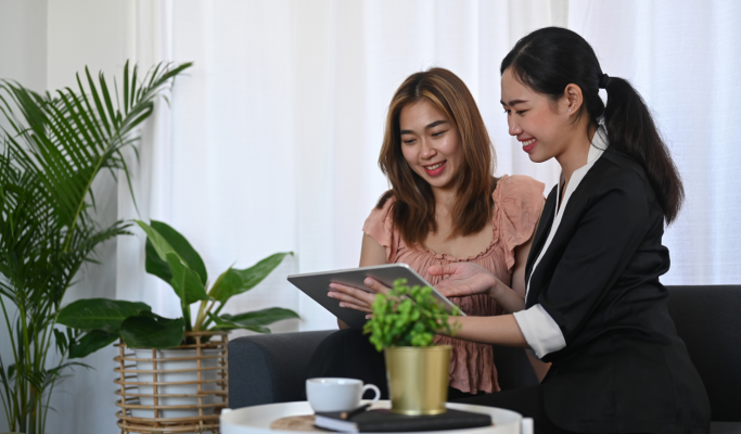 Two woman discussing content on an iPad.