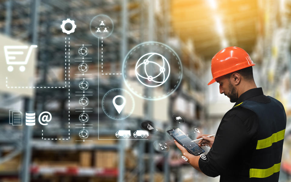 Man working in warehouse looking at tablet for supply chain results.