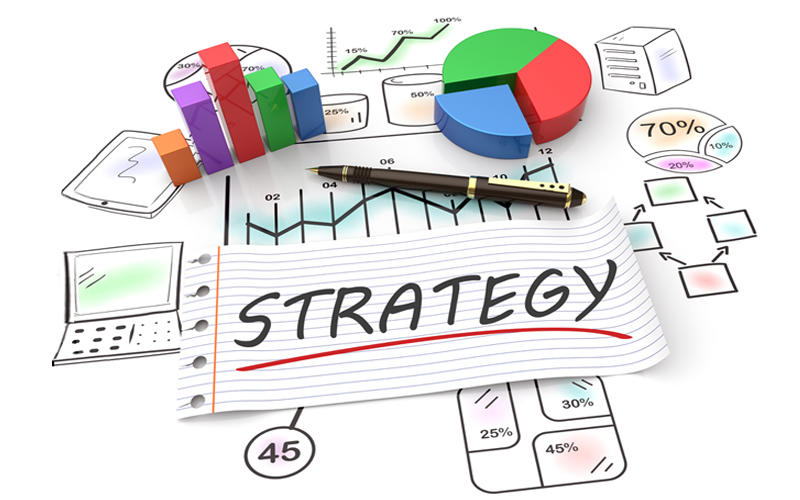 Strategy written on a paper with chart and graphs in the background.