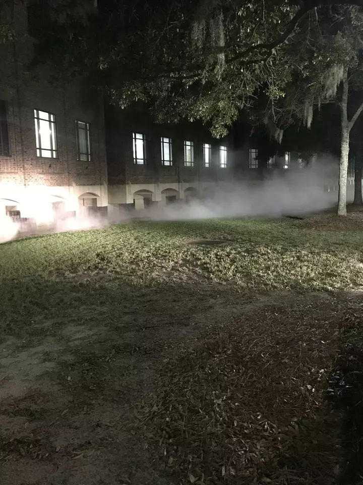 A building at night with a liquid nitrogen leak causing a creepy looking fog around the base of the building.