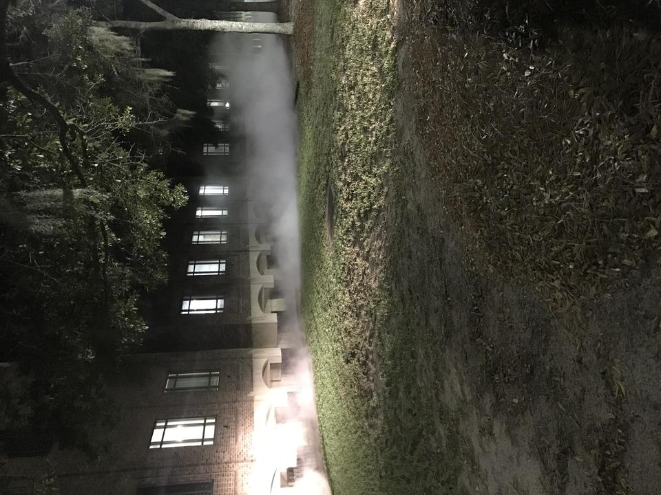 A building at night with a liquid nitrogen leak causing a creepy looking fog around the base of the building.
