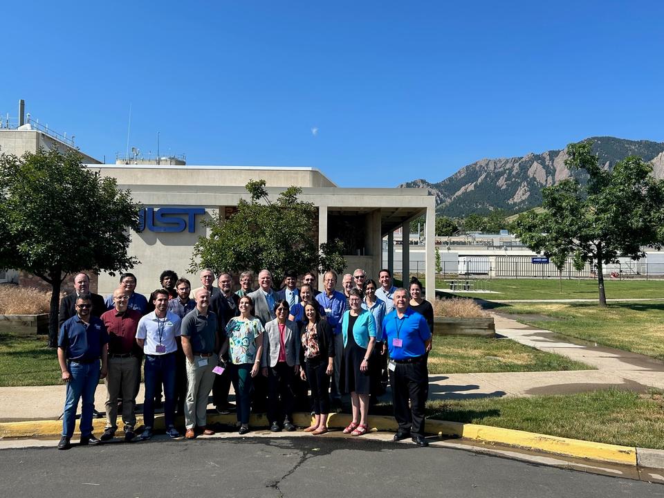 A group of people posing for a photo in front of the NIST Boulder campus