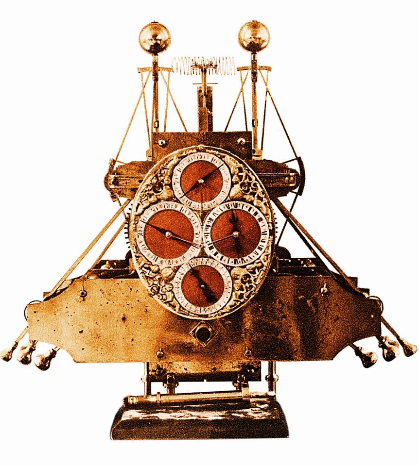Complex historical scientific device is wider at the bottom than the top and has four dials on the front. 