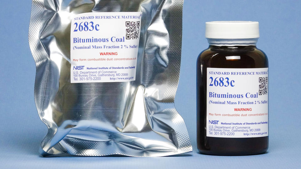 Photograph of a labeled mylar envelop and labeled amber bottle containing SRM 2683c Bituminous Coal. 