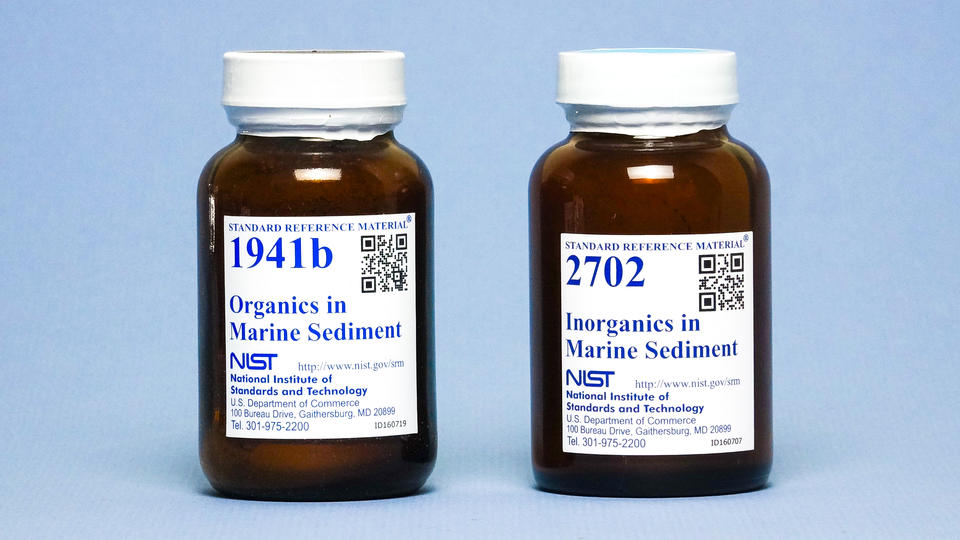 Photograph of two labeled amber bottles containing marine sediments.