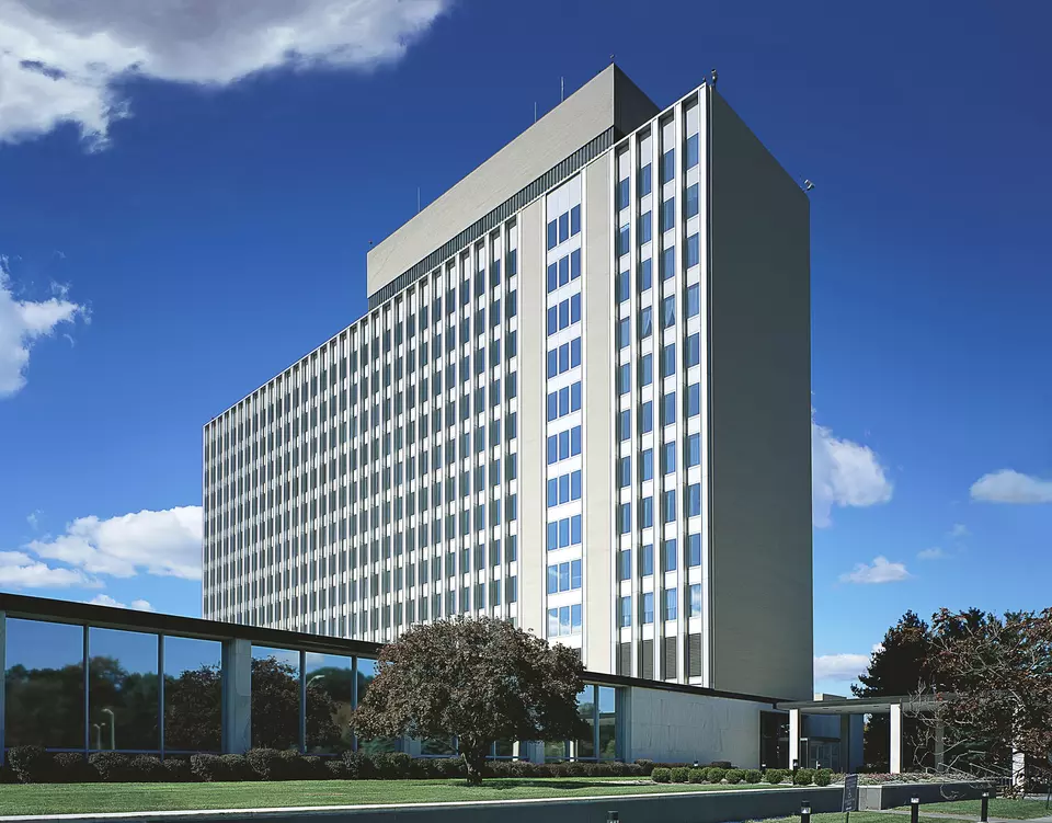 Narrow 11-story building rises into a blue sky.