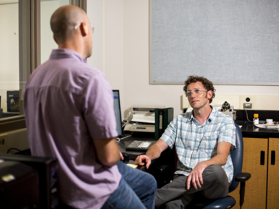 Photograph of two men conversing with each other.