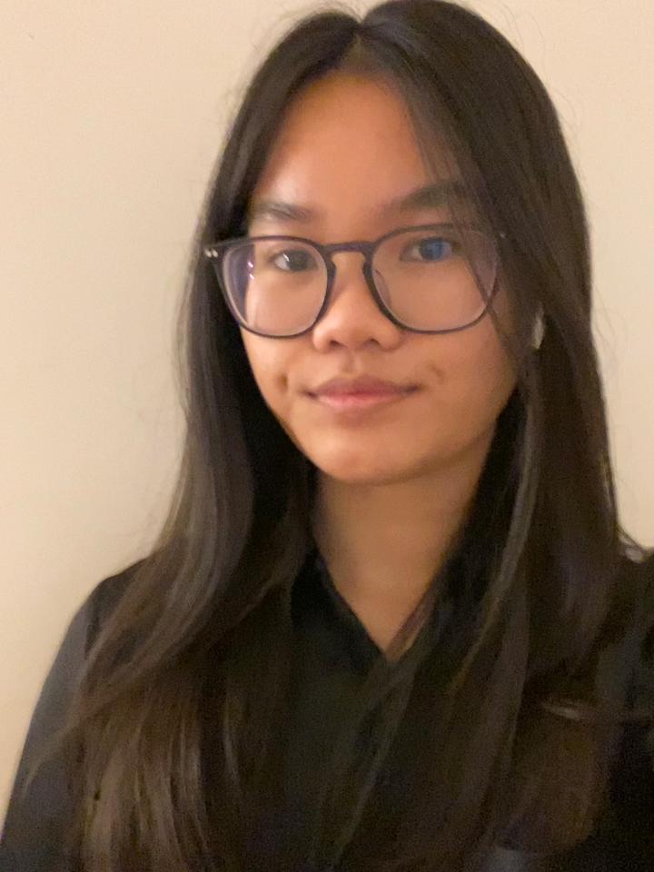 portrait of a woman with black hair wearing a black top and glasses