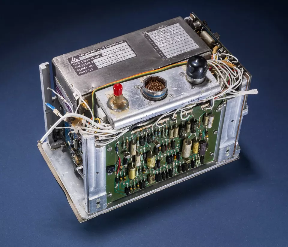 Small rectangular device is packed with wires, circuits and knobs.