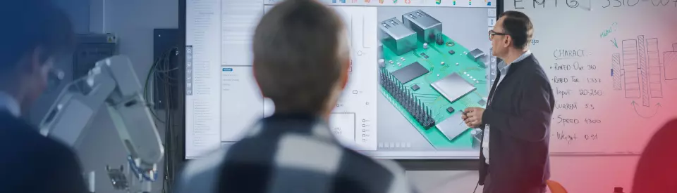 Man standing in from of presentation screen displaying microcontroller