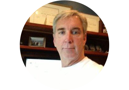 person with short gray hair, standing in an office