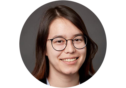 person with shoulder-length brown hair and glasses