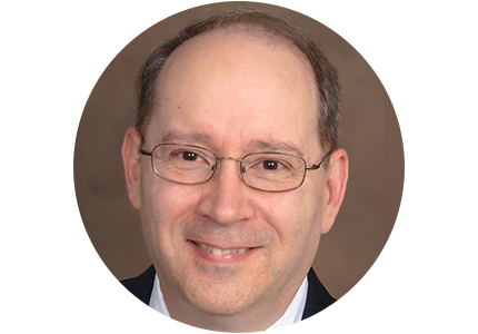 person with glasses, wearing a suit