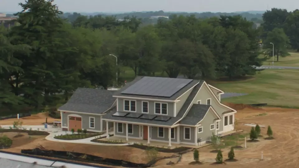 A newly built two-story home has solar panels on the roof.